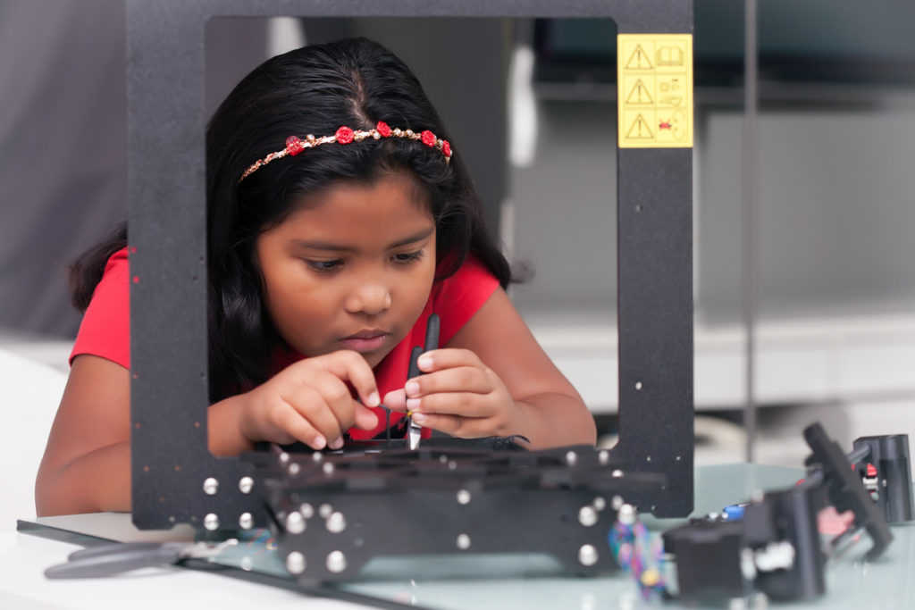 girl assembling a 3D printer kit for STEM summer camp